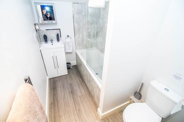 This bathroom have a bath with rainfall shower overhead.